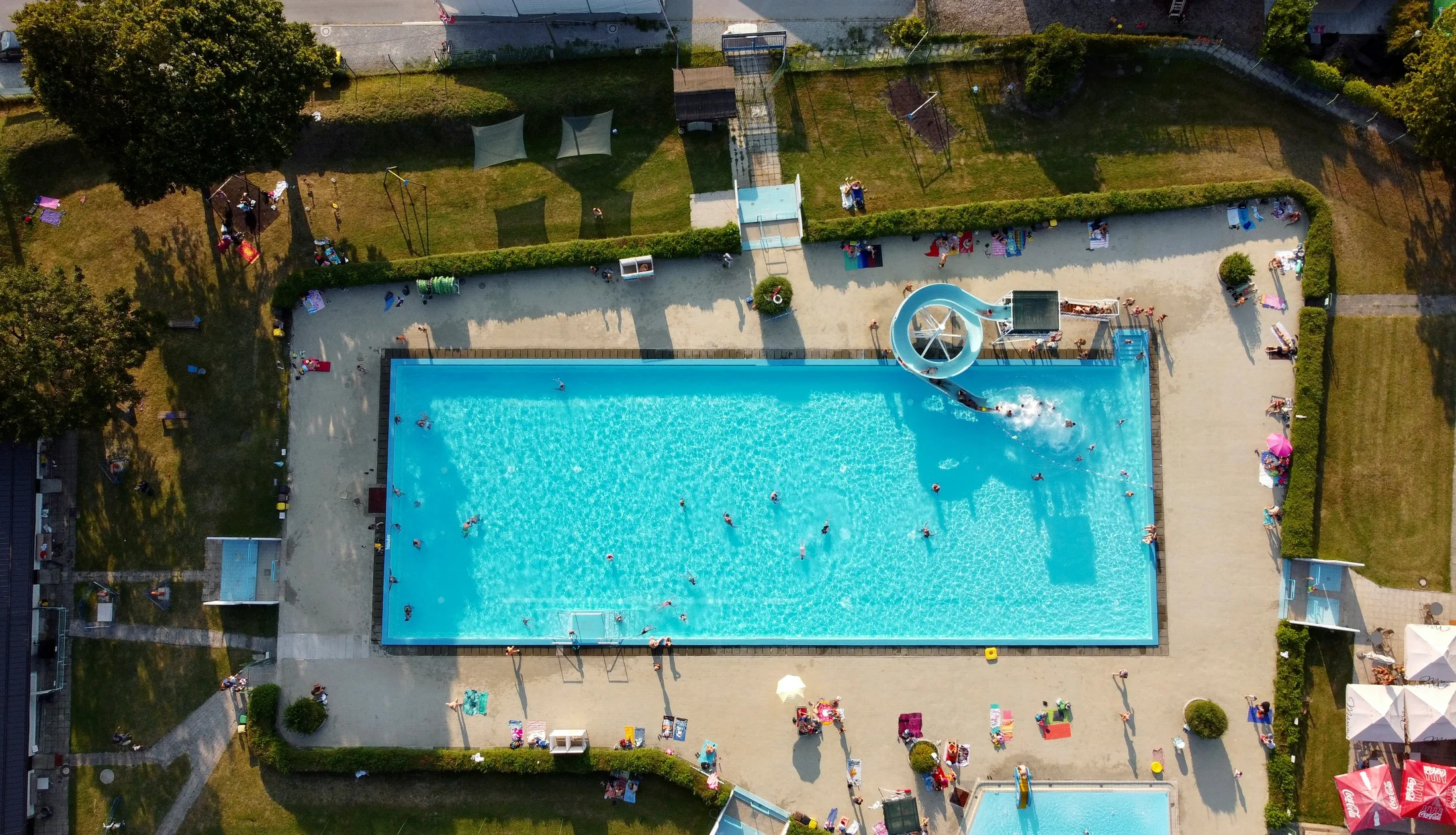 Vista aérea de una instalación acuática con personas disfrutando de la piscina